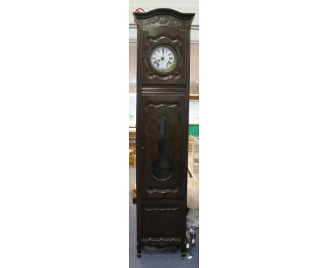 A late 19th Century French oak longcase clock with eight day brass and tin cased movement striking on a bell, the circular en