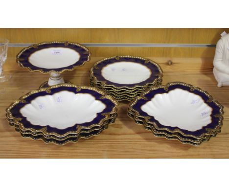 A Royal Crown Derby bone china part dessert service, circa 1899 and 1902, each blue and gilt wavy rim heightened with white e