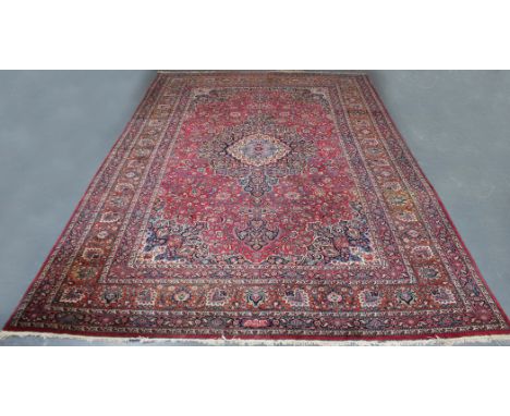 An oversized Tabriz carpet, Central Persia, early 20th Century, the magenta field with a foliate medallion supported by profu