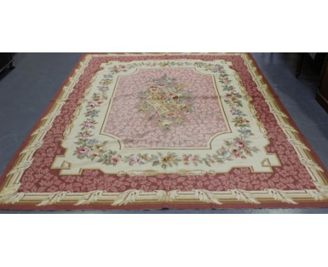 An Aubusson style carpet, late 20th Century, the pink field with a musical instrument and flower spray, within a pink foliate