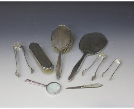 A silver mounted three-piece dressing table set with engine turned decoration, comprising hand mirror, hairbrush and clothes 