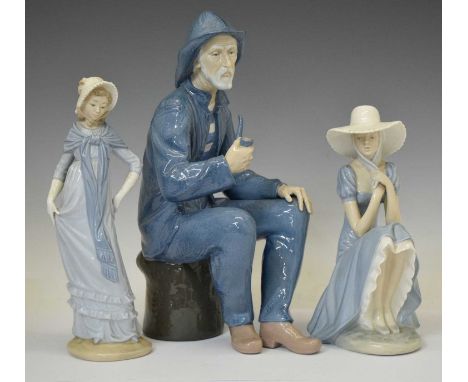 Nao porcelain figure of a seated fisherman with pipe, together with two ladies, printed marks, 39cm high and smaller (3)
