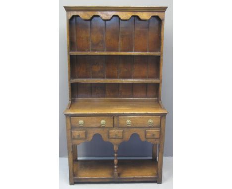 SMALL REPRODUCTION OAK DRESSER having moulded cornice with shaped apron over two shelves to the boarded rack back, the base w