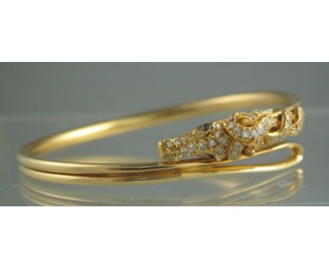 AN 18CT GOLD BANGLE modelled as a horse's head encrusted with diamonds together with a matching ring. Ring size L. Weight in 