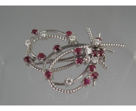 A DIAMOND AND RUBY BROOCH. The white metal brooch scattered with fourteen rubies and eight diamonds. 4.5 x 3.5cm approx. Weig