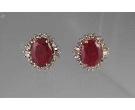 A PAIR OF OVAL RUBY AND DIAMOND EARRINGS. The rubies approx 10 x 8mm, surrounded by round and baguette cut diamonds. Weight 6