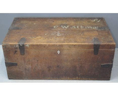 A 19TH CENTURY MIXED WOODS TRAVELLING CHEST OR TRUNK of rectangular form having metal banding and metal loop handled carrying