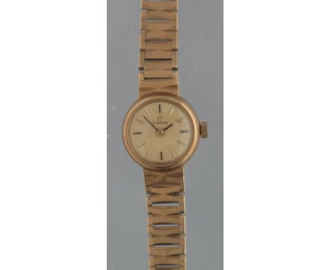 OMEGA 9CT GOLD LADIES BRACELET WRISTWATCH having circular dial with baton numerals and engine turned graduated bracelet strap