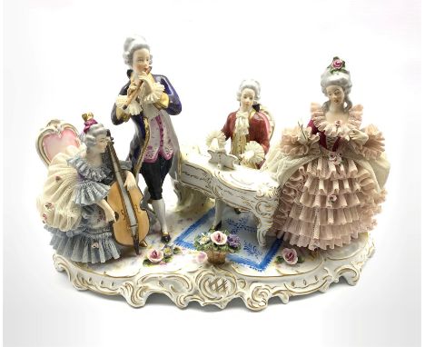 German porcelain musical figure group, comprising a seated gentleman playing a piano, a standing gentleman playing a flute an