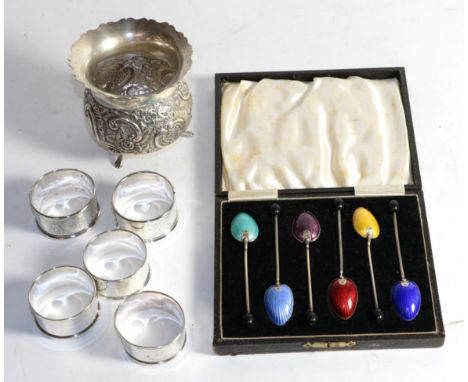 A set of six enamel coffee spoons in fitted case; five silver napkin rings; and a footed vase 