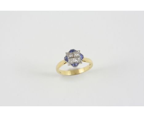 A SAPPHIRE AND DIAMOND CLUSTER RING the four single-cut diamonds are set within a surround of four calibre-cut sapphires in 1