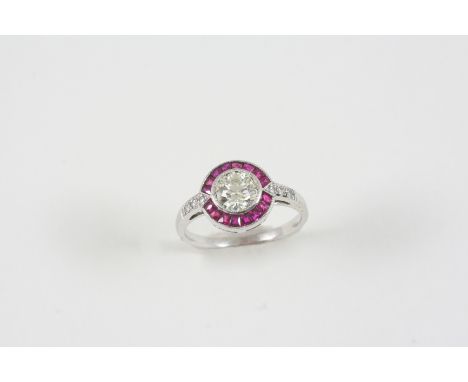 A RUBY AND DIAMOND CLUSTER RING the central circular-cut diamond is set within a surround of calibre-cut rubies, with small d