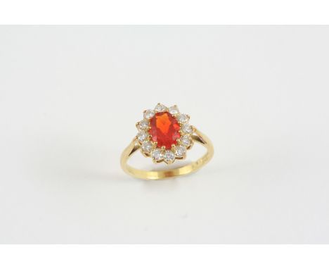 A FIRE OPAL AND DIAMOND CLUSTER RING the oval-shaped fire opal is set within a surround of circular-cut diamonds, in 18ct. go