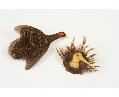 A GOLD WOODCOCK BROOCH the gold head with cabochon ruby eye in a surround of woodcock feathers, inscribed to the reverse 9 Au