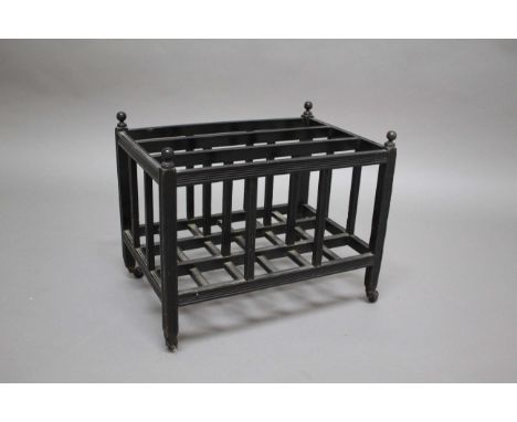 AESTHETIC MOVEMENT CANTERBURY an ebonised wooden canterbury of slatted construction, with turned finials on each corner and w