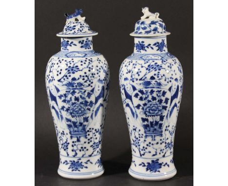 PAIR OF CHINESE BLUE AND WHITE VASES AND COVERS, Kangxi style, of inverted baluster form painted with figures beside a vase, 