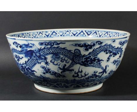 LARGE CHINESE BLUE AND WHITE PUNCH BOWL, late 19th or 20th century, painted with a central scrolling dragon, the exterior wit