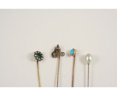 A DIAMOND AND GEM SET STICK PIN formed as a man riding a penny farthing bicycle, set with rose-cut diamonds and a cabochon ru