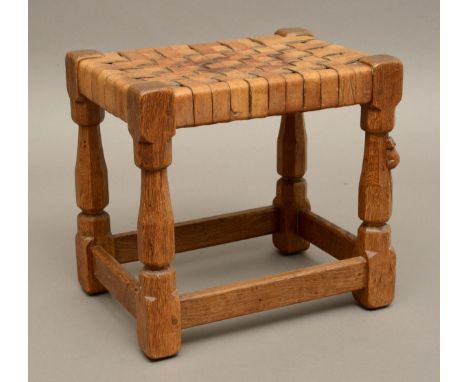 ROBERT THOMPSON OF KILBURN - MOUSEMAN OAK STOOL a carved oak joint stool with octagonal legs and leather lattice seat. Carved