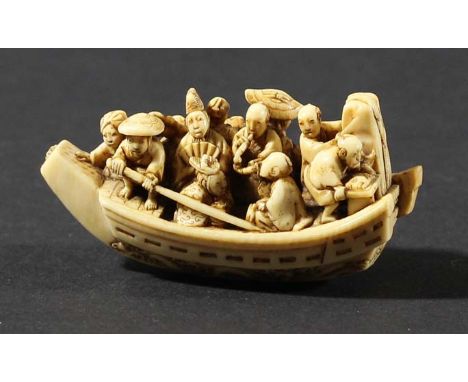 JAPANESE IVORY NETSUKE, by Ikkosai Toun, Edo period, carved as a boat full of people, waves breaking along the hull, signatur