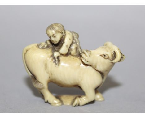 A 19TH CENTURY JAPANESE MEIJI PERIOD CARVED IVORY NETSUKE OF A BOY ON A WATER BUFFALO BY HIDEYUKI, the head of the animal tur