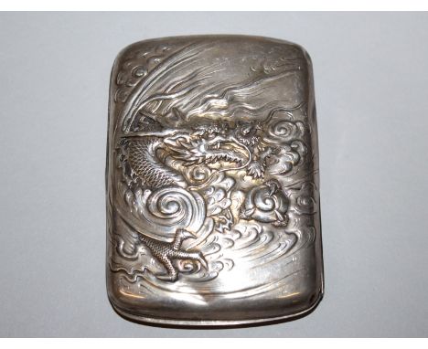 A GOOD SIGNED EARLY 20TH CENTURY JAPANESE SILVER CIGARETTE CASE, embossed with a dragon grasping a pearl and emerging from cl