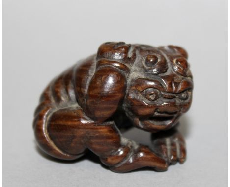 A 19TH/20TH CENTURY JAPANESE CARVED WOOD NETSUKE OF AN ONI, unsigned, the demon seated in fear with its hands clasped over it