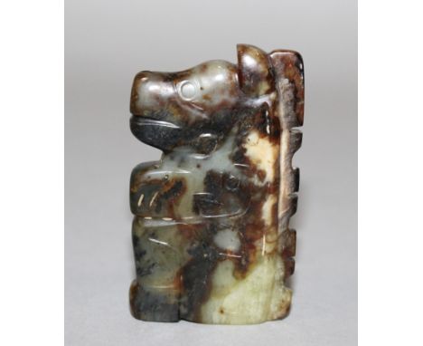 A CHINESE JADE PENDANT, in the form of an archaic mythical animal, the stone a mixture of celadon green, grey and russet tone