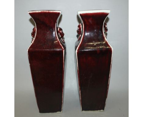 A PAIR OF CHINESE FLAMBE PORCELAIN VASES, the sides of each square-section body applied with a glaze of a dark red streaked t