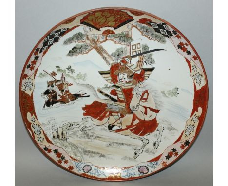 AN EARLY 20TH CENTURY JAPANESE KUTANI PORCELAIN DISH, painted with two samurai on horseback, the base with a Kutani mark in i