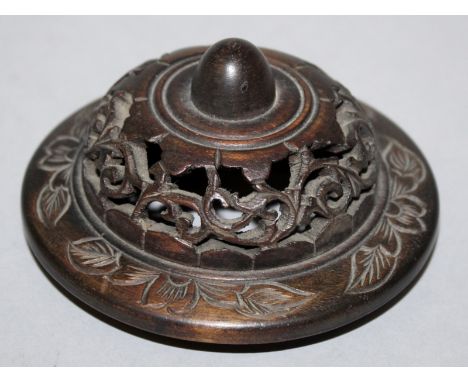 AN EARLY 20TH CENTURY CHINESE CARVED HARDWOOD VASE COVER, with pierced scroll decoration, 3.75in wide, to fit a vase with an 