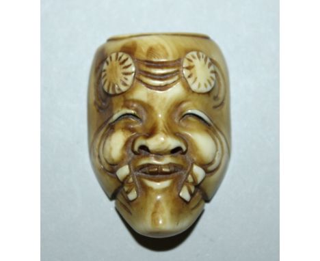 A SIGNED JAPANESE MEIJI PERIOD STAINED IVORY KABUKI NOH OKINA MASK NETSUKE, circa 1900, carved in the form of an old man with