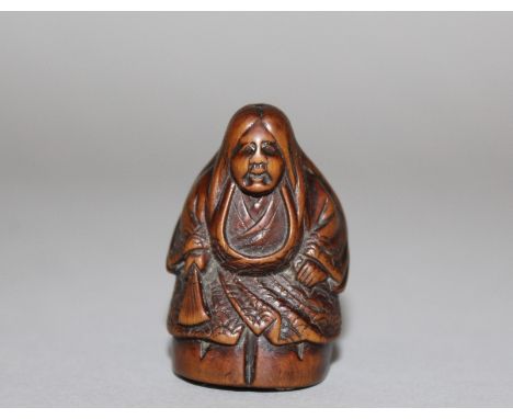 A GOOD 19TH JAPANESE BOXWOOD & IVORY NETSUKE OF A SHOJO, unsigned, standing in enveloping robes and holding a fan, her feet i