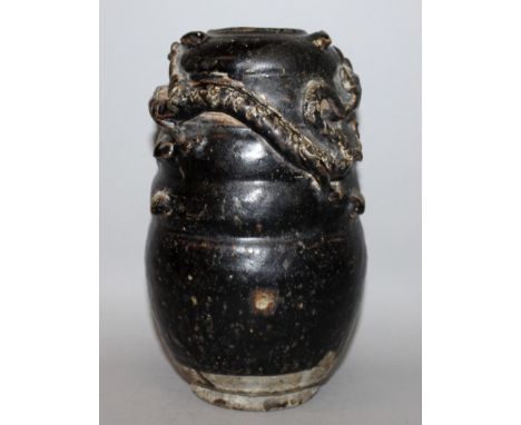 A CHINESE SONG DYNASTY HENAN BLACK GLAZED CERAMIC JAR, the ribbed body moulded in high relief with a dragon pursuing a pearl,