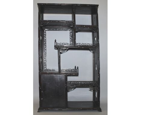 A GOOD EARLY 20TH CENTURY CHINESE CARVED HARDWOOD OPEN DISPLAY CABINET, with staggered and variously sized shelves fitted wit