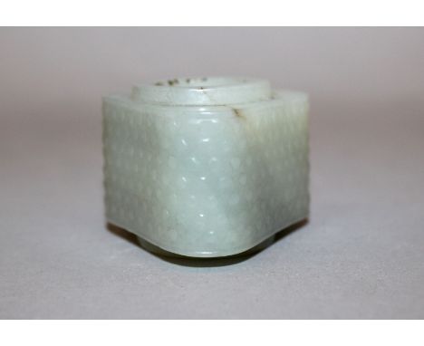 AN UNUSUAL CHINESE TRIANGULAR-SECTION JADE CONG, the sides with a formal relief stipple design, 1.6in high.