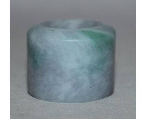 A CHINESE JADE-LIKE ARCHER’S RING, the stone of predominantly lavender tone with apple-green inclusions, 1.4in diameter & 1.1