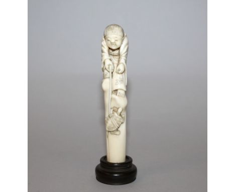 A GOOD QUALITY JAPANESE MEIJI PERIOD IVORY CANE HANDLE, together with a fixed wood stand, the ivory carved in the form of a b