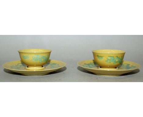 A PAIR OF CHINESE GREEN ENAMELLED YELLOW GROUND PORCELAIN TEABOWLS & SAUCERS, each piece decorated with stylised dragons, eac