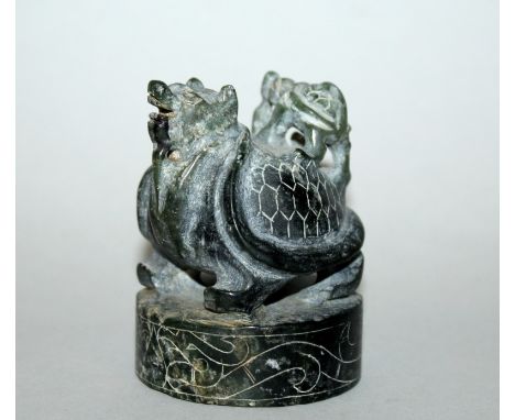 AN EARLY 20TH CENTURY CHINESE CARVED JADE SEAL, of circular section, the plinth surmounted by a mythical tortoise and its you