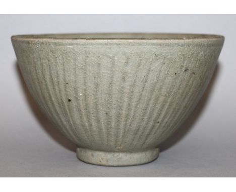 A THAI SAWANKHALOK CELADON CERAMIC BOWL, 14th/16th Century, the steep sides moulded beneath the glaze with narrow extended st