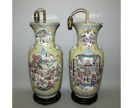 A GOOD PAIR OF 19TH CENTURY CHINESE YELLOW GROUND FAMILLE ROSE PORCELAIN VASES, each with a wood base and fitted for electric