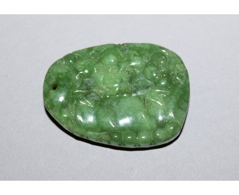 A CHINESE APPLE-GREEN JADE-LIKE PENDANT, decorated in low relief with lingzhi, 2in high x 1.4in wide at widest points.