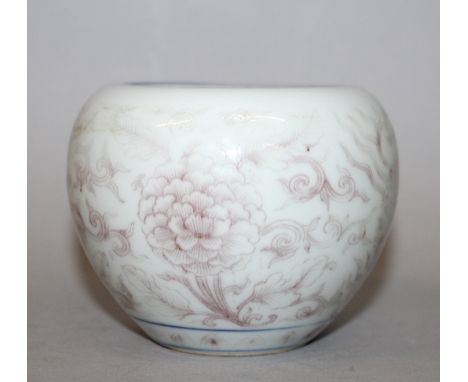 A CHINESE COPPER-RED PORCELAIN BRUSHWASHER, the sides decorated with a design of scroll-stemmed flowerheads, the curved inner
