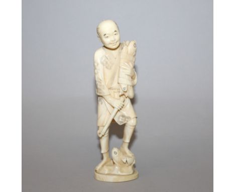 AN EARLY 20TH CENTURY SIGNED JAPANESE IVORY CARVING OF A FISHERMAN, holding a reed wrapped bundle of fish and standing on a r