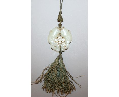 A GOOD QUALITY 19TH CENTURY CHINESE PALE CELADON JADE PENDANT, with attached tassels, well carved and pierced in the form of 