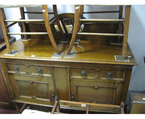 A 1920's Oak Sideboard, with a low back, oval central mirror, two small drawers, over two cupboard doors on barley twist and 
