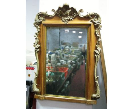 A Continental Pine Framed Bevelled Wall Mirror, with scroll mounts 57cm wide.