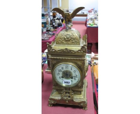 A Brass Eight Day Mantel clock, cast decoration of foliage, scrolls and mask heads, all surmounted with an eagle, ivorine cha