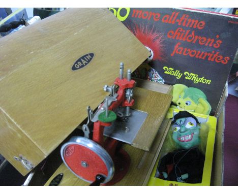 A Grain Mid XX Century Childs Toy Sewing Machine, four records, Pelham Puppet 'Wicked Witch' oval wall mirror.